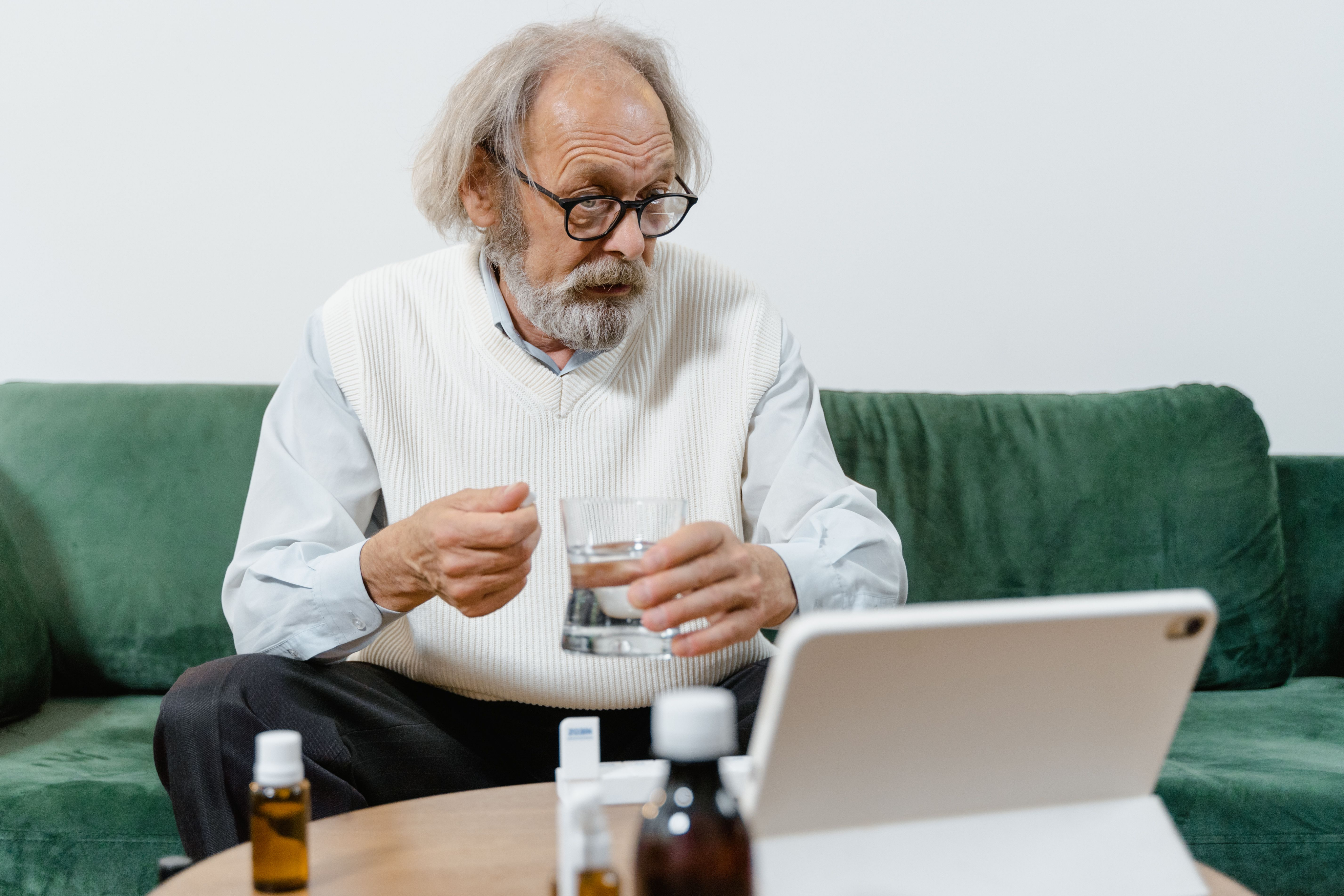 Man using a tablet for a virtual care visit at home