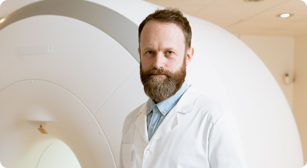 Dr. James Whitaker in a white coat in a clinical setting